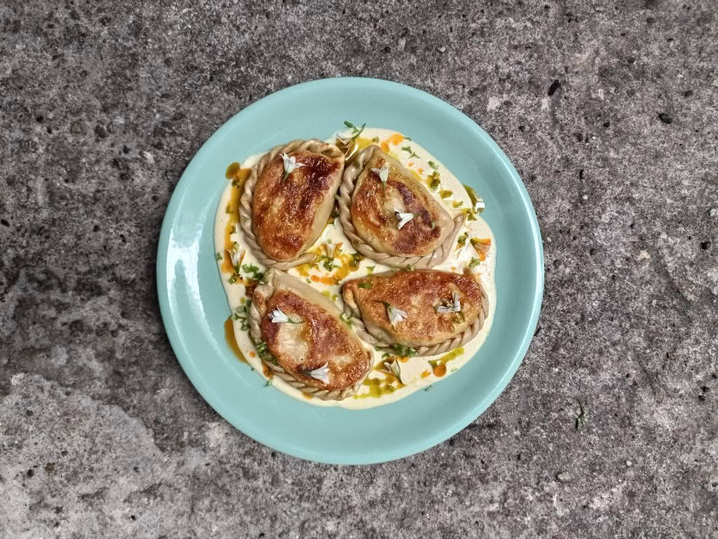 Cuisine Good Food Guide 2026 Graze Onion weed pierogies with yoghurt sauce and chili oil – Photo credit Stina Persen